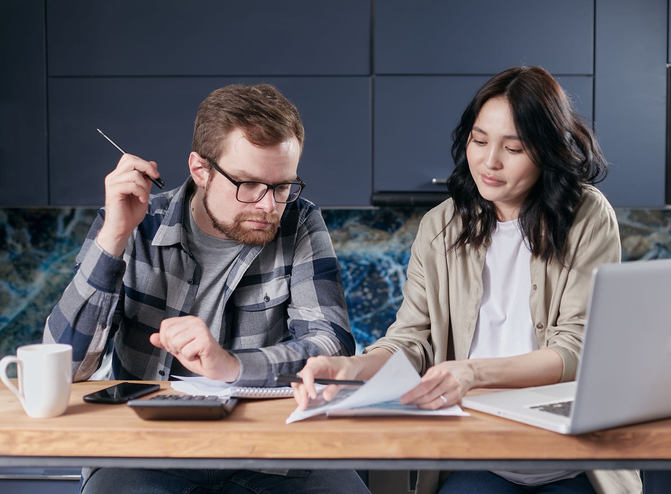A couple reviewing and calculating their household bills together at home